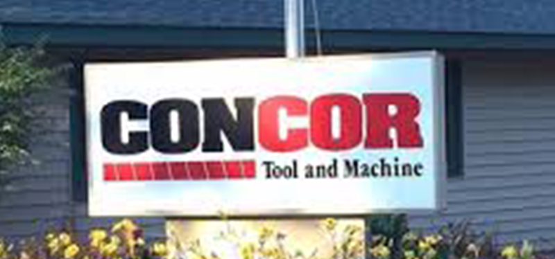 Concor Tool and Machine office sign, featuring bold company branding outside a well-maintained building with surrounding plants.