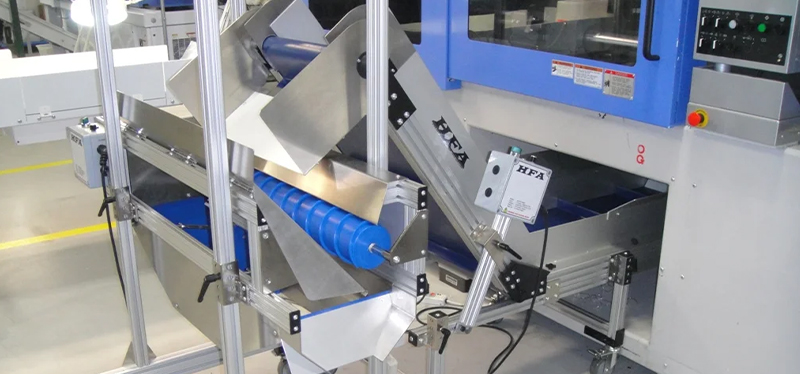 Harvard Factory Automation (HFA) custom conveyor system with blue rollers, designed for efficient material handling in a manufacturing environment.