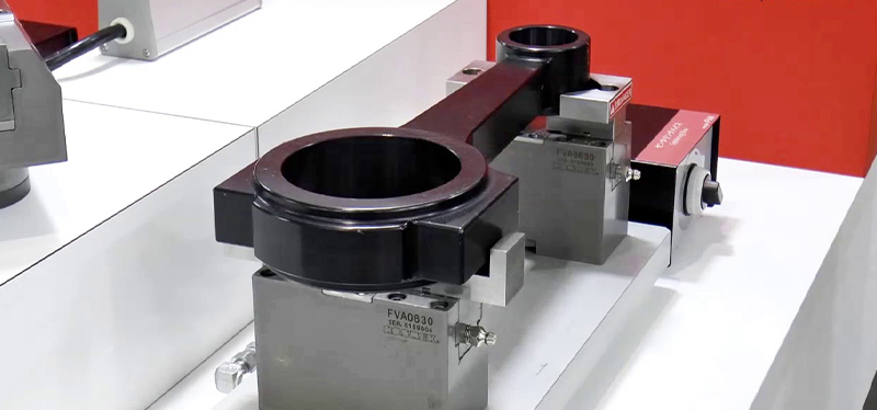 Kosmek quick mold clamping machine displayed on a table, showcasing advanced precision components for efficient injection molding operations.